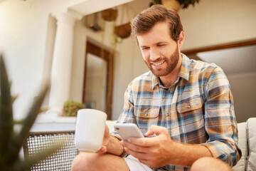 Canvas Print - Phone, coffee and communication with a man on a social media app and mobile technology at home. Tea, relax and internet with a young male reading and typing a message while sitting in the living room