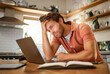 © Nicholas Felix/peopleimages.com - Stress, laptop finance and planning man thinking of home loan, investment savings and future money growth goals in house kitchen. Anxiety, burnout or sad guy with debt depression after trading budget