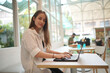 © FotoArtist - Technology and people concept, young woman using laptop and internet technology and sitting on the desk with laptop computer.
