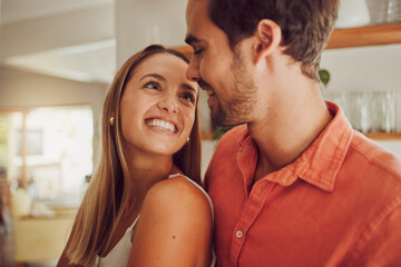 Wall Mural - Couple, smiling and in love having a lovely romantic moment in the kitchen at home. Man and woman spending affectionate free time together, happy and bonding with embraced happiness.