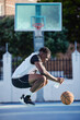 Basketball, sport and fitness with a young man on a court for exercise, training and workout. Health, wellness and fitness with a sporty person resting and drinking water after sports practice