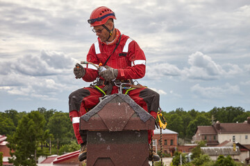 A specialist is repairing the roof. Rope access