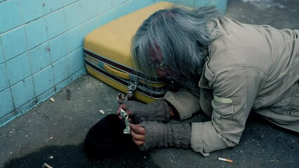 Wall Mural - 4k, A long-haired old man, a homeless man in a shabby-dressed street, was delighted that he had received money from a yellow purse donor on the floor. waiting for help from others