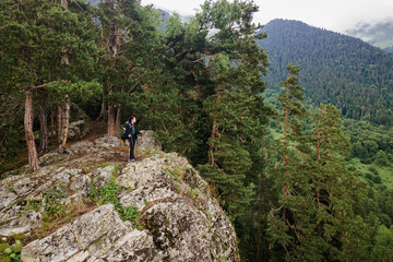 Young female adventure hiker reaching top of wild viewpoint, aerial view