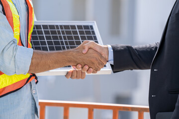 Poster - Close up businessman and engineers shaking hands after discussing install solar panels on houses under construction,Renewable energy for residential.