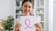 © Nattakorn - Smiling young Asian woman show pink ribbon sign as sign of October Breast Cancer Awareness month