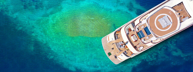 Wall Mural - Aerial drone ultra wide top down photo of luxury exotic yacht with wooden deck and helipad anchored in paradise turquoise bay