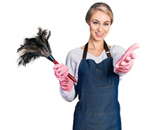 Beautiful Young Blonde Woman Wearing Apron Holding Cleaning Duster Smiling Friendly Offering Handshake As Greeting And Welcoming. Successful Business.