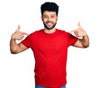 © Krakenimages.com - Young arab man with beard wearing casual red t shirt looking confident with smile on face, pointing oneself with fingers proud and happy.