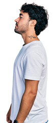 Sticker - Hispanic young man with beard wearing casual white t shirt looking to side, relax profile pose with natural face and confident smile.