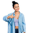 © Krakenimages.com - Beautiful hispanic woman wearing casual denim jacket and glasses doing happy thumbs up gesture with hand. approving expression looking at the camera showing success.