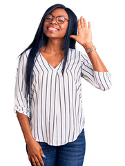 Canvas Print - Young african american woman wearing casual clothes and glasses waiving saying hello happy and smiling, friendly welcome gesture