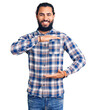 © Krakenimages.com - Young arab man wearing casual clothes gesturing with hands showing big and large size sign, measure symbol. smiling looking at the camera. measuring concept.