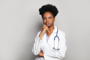 Wall Mural - Thinking doctor woman on white background