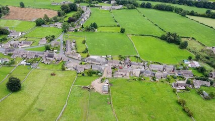 Wall Mural - Aerial footage of the beautiful village of Thoralby in the Richmondshire district of North Yorkshire in the UK, showing the small British village and surrounding green fields in the summer time