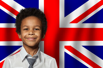 Wall Mural - British kid boy on flag of United Kingdom background. Education and childhood concept