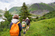 © Anna - Father and sons hiking together, view from the back, long walk, summer activities for family in the mountains.