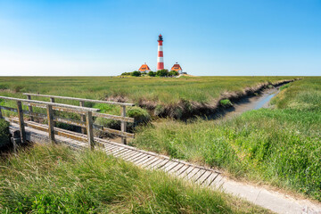 Wall Mural - Westerheversand Lighthouse along the salt marsh, Westerhever, Nordfriesland, Schleswig-Holstein, Germany	