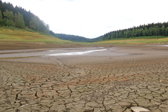 a dried up empty reservoir and dam during a summer heatwave, low rainfall and drought in saxony, ger