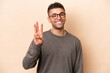 © luismolinero - Young Brazilian man isolated on beige background happy and counting three with fingers