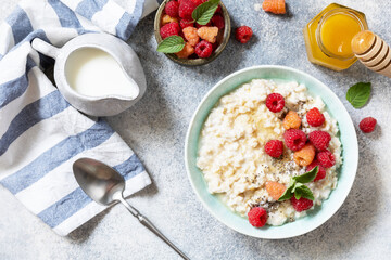 Wall Mural - Oatmeal porridge in ceramic bowl decorated with fresh berries raspberries and chia seeds served with honey. Healthy diet breakfast. View from above.