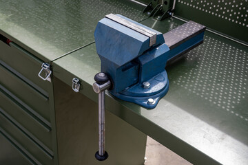 Poster - Vise grip stationary. Steel vise fixed on table. Tool for mechanical work. Mechanics desktop. Mechanical equipment for auto mechanic. Blue vise close-up. Concept sale of equipment for mechanic