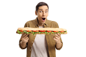 Young man eating a tasty long sandwich in a baguette