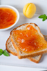 Wall Mural - Toasts of bread with apricot jam and fresh fruits with mint.