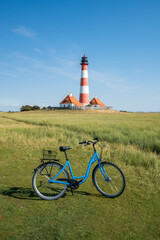 Wall Mural - bicycle tour to the westerheversand lighthouse, westerhever, nordfriesland, schleswig-holstein, germ