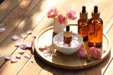 Fototapeta Kawa jest smaczna - Bottles of rose essential oil and flowers on wooden table, space for text