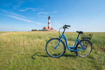 Wall Mural - Bicycle tour to the Westerheversand lighthouse, Westerhever, Schleswig-Holstein, Germany