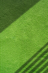 Wall Mural - Background texture with roughness and detail grain of vintage green concrete wall in vertical frame with sunlight and shadow on surface