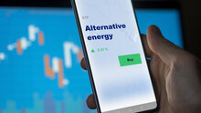 An Investor's Analyzing The Alternative Energy Etf Fund On Screen. A Phone Shows The  Climate Ecologic Sustainable ETF's Prices Stocks To Invest