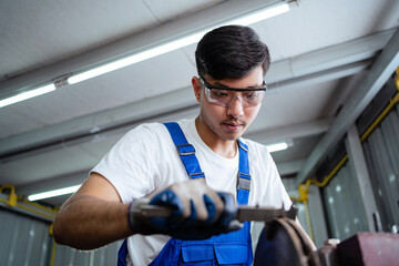 Canvas Print - Asian engineers or Asian technicians work in industrial plants. Metal grinding machines. working in the factory workers working in the factory. work factory industrial concept.