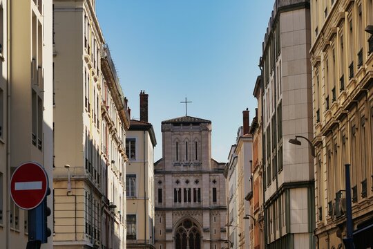 Street buildings leading to the Eglise Saint Andre under the blue sky in Lyon