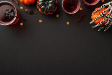 Halloween Concept. Top View Photo Of Drink In Glasses With Floating Spiders Skeleton Hand Holding Pumpkin Insects Centipedes Cockroach And Confetti On Isolated Black Background With Blank Space