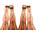 beautiful pairs of smooth woman's legs after laser hair removal with protection glasses for laser removal on the white background