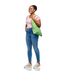 Sticker - sustainability and people concept - happy smiling young african american woman with green reusable canvas bag for food shopping walking over white background