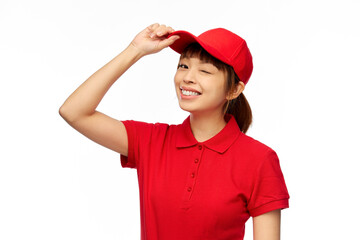 Poster - profession, job and people concept - happy smiling delivery woman in red uniform over white background