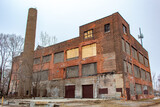 Fototapeta Londyn - Old red brick abandoned factory industrial building in Detroit Michigan on a cold winter snow day