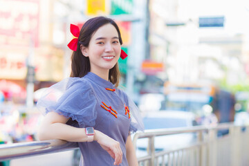 Asian beautiful woman in a qipao is standing smiling happily. Roadside China Town, Thailand Chinese New Year theme