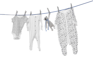 Wall Mural - Different baby clothes and toy drying on laundry line against white background