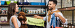 © LIGHTFIELD STUDIOS - Side view of cheerful interracial couple holding poodle and animal cage in store, banner