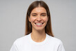 Headshot of happy woman with healthy white toothy smile on gray studio background