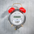 Electric meter wiith alarm clock. Time to pay utility bills and debt for electricity consumption concept.