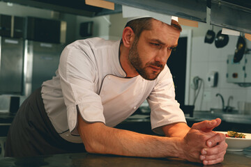 Tired chef on kitchen restaurant waiting for a new order