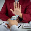 © Puwasit Inyavileart - Businessmen give dollars to bribe employees in signing contracts to buy illegal land and real estate, Business fraud and social injustice, Anti Bribery and corruption concept.