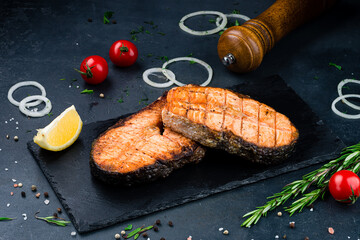 Wall Mural - Grilled salmon fish on black stone background