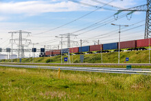 Cargo Train Carrying Containers Along A Motorway In A Port Area On A Clear Summer Day