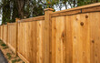 Nice new wooden fence around house. Wooden fence with green lawn. Street photo